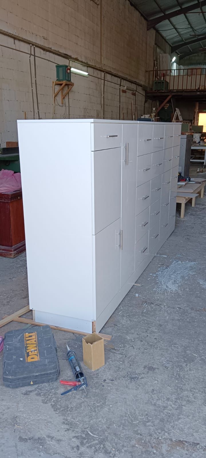 A space-maximizing bedroom installation featuring a floating corner study desk smoothly transitioning into a full-height wardrobe system equipped with multi-tier square drawer units. - Photo 3