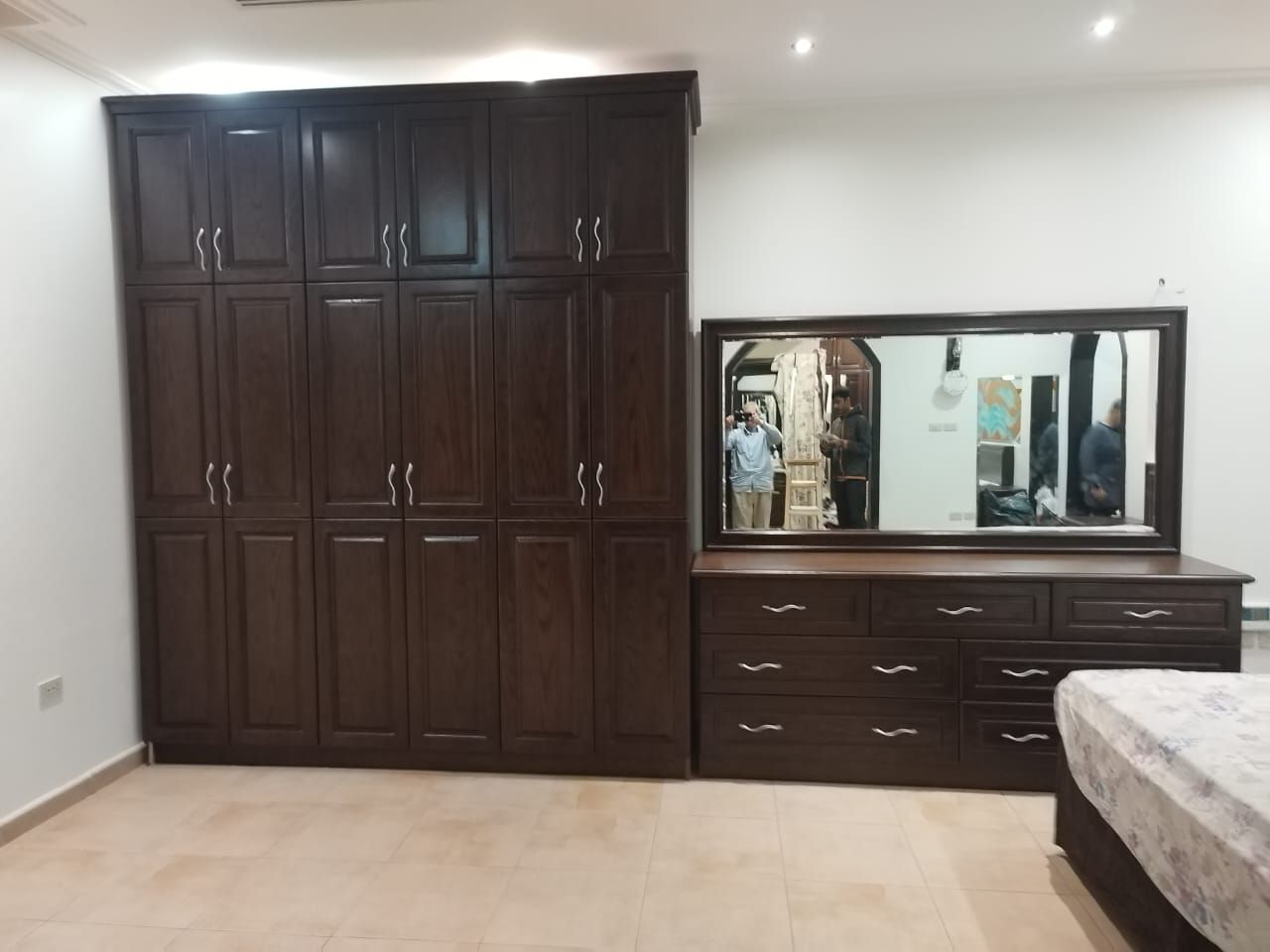 A premium full bedroom furniture set featuring a rich natural wood oak finish, including a clean-lined bedframe with an integrated headboard, two matching minimalist nightstands, a spacious multi-drawer dresser, and a large matching wardrobe closet. - Photo 1