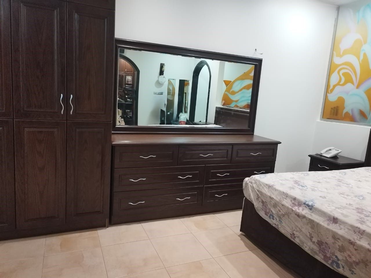 A premium full bedroom furniture set featuring a rich natural wood oak finish, including a clean-lined bedframe with an integrated headboard, two matching minimalist nightstands, a spacious multi-drawer dresser, and a large matching wardrobe closet. - Photo 2