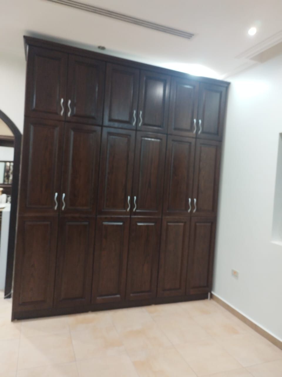 A premium full bedroom furniture set featuring a rich natural wood oak finish, including a clean-lined bedframe with an integrated headboard, two matching minimalist nightstands, a spacious multi-drawer dresser, and a large matching wardrobe closet. - Photo 6