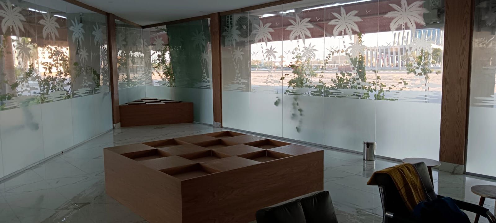 Comprehensive commercial interior woodwork including ash wood wall cladding, structural column wraps, floating shelves, service counters, and geometric grid display plinths. - Photo 1