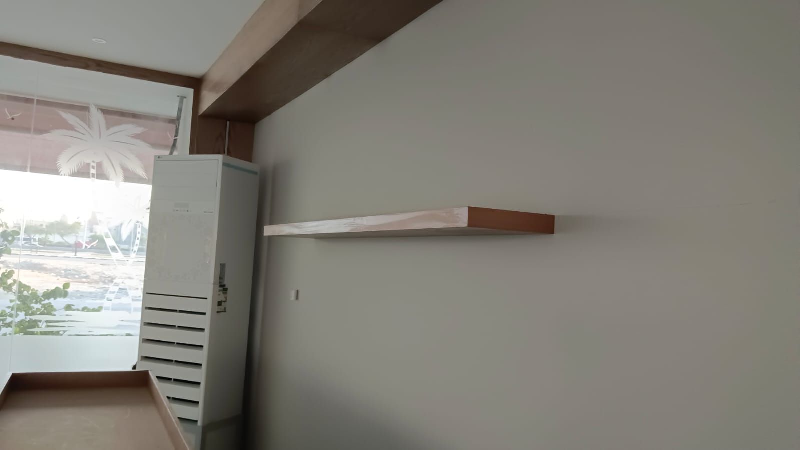Comprehensive commercial interior woodwork including ash wood wall cladding, structural column wraps, floating shelves, service counters, and geometric grid display plinths. - Photo 3