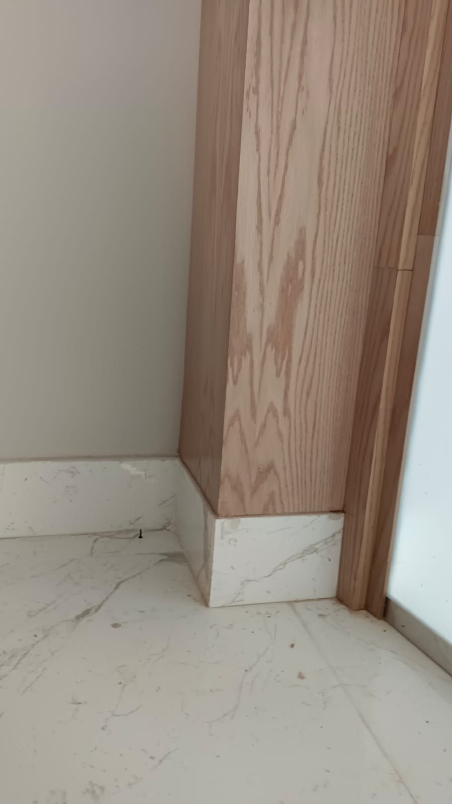 Comprehensive commercial interior woodwork including ash wood wall cladding, structural column wraps, floating shelves, service counters, and geometric grid display plinths. - Photo 5