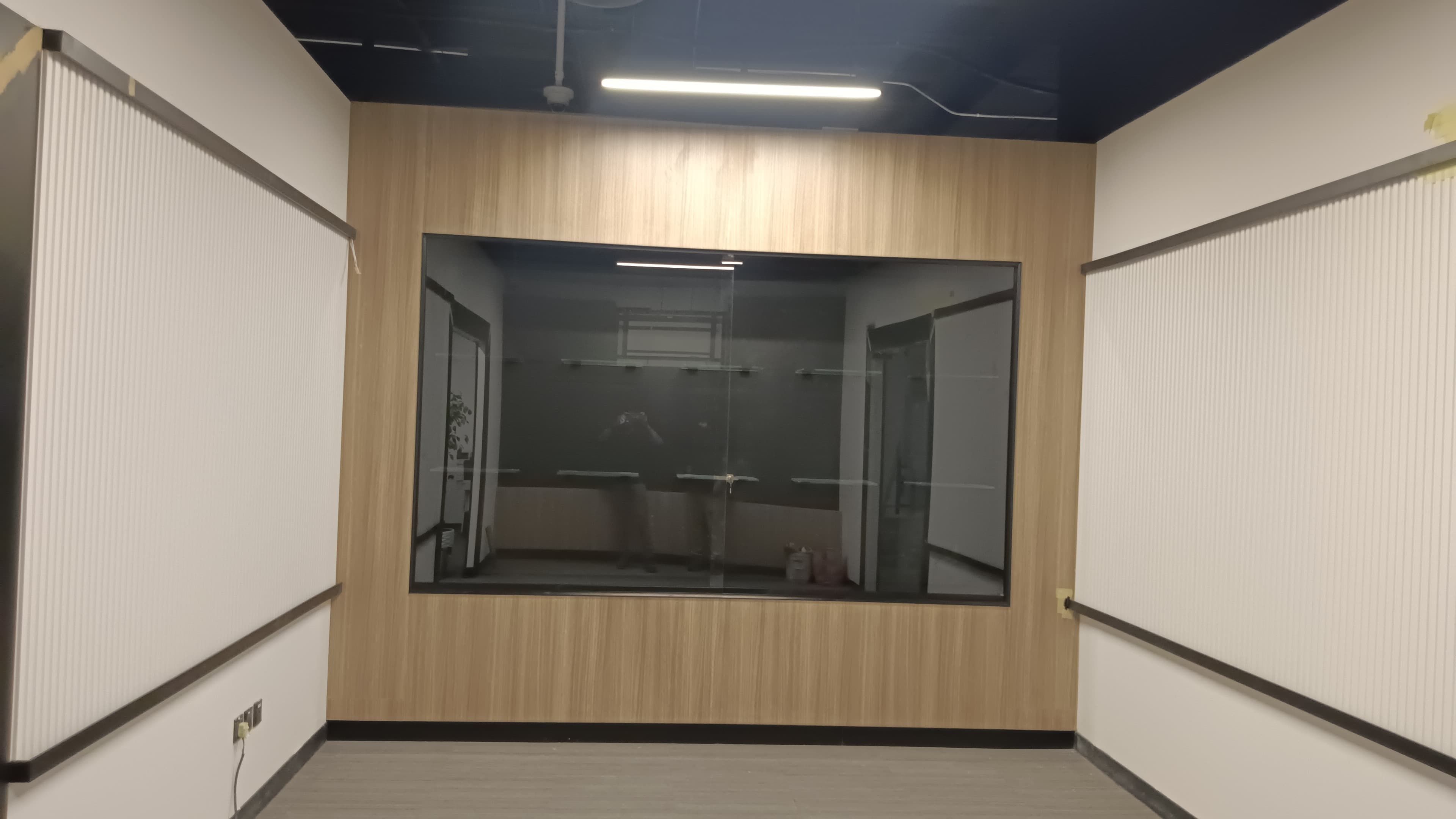 طقم تكسية جدارية فاخر للمباني التجارية، يتميز بجدار أساسي من الخشب الطبيعي يحتوي على تجويف عرض كبير مدمج للجوائز أو المنتجات، تحيط به ألواح تكسية جدارية مضلعة باللون الأبيض. - صورة 1