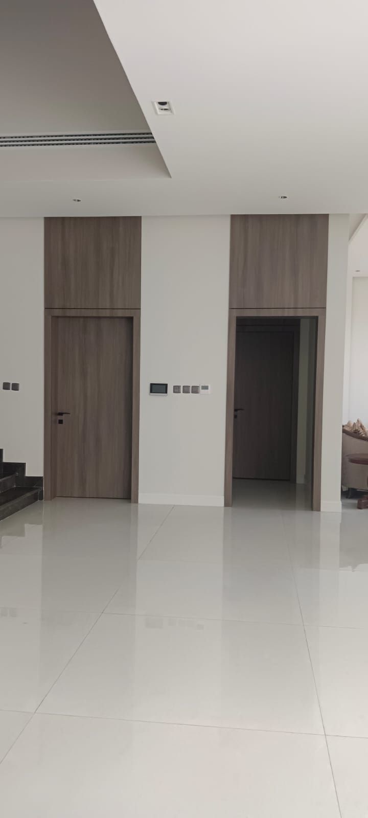 Premium floor-to-ceiling wood veneer wall cladding integrated with flush interior doors and an elevator surround for a seamless architectural finish. - Photo 2