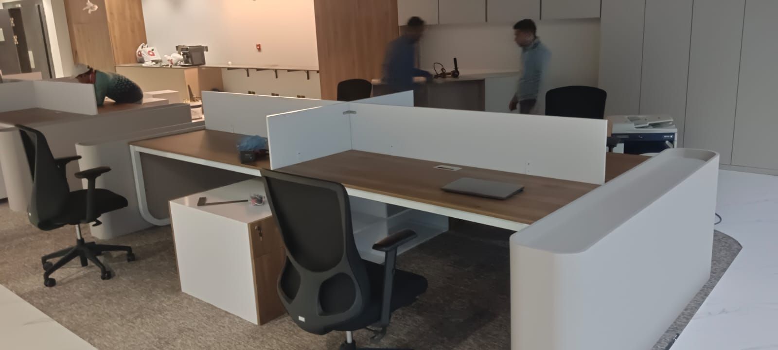 تجهيز مكتب شركات حديث يتميز بمحطات عمل خطية مجزأة تفصل بينها ألواح قواطع مدمجة، متكاملة مع مكاتب تنفيذية مستقلة متطابقة ووحدات أدراج تخزين متحركة أسفل المكاتب. - صورة 1