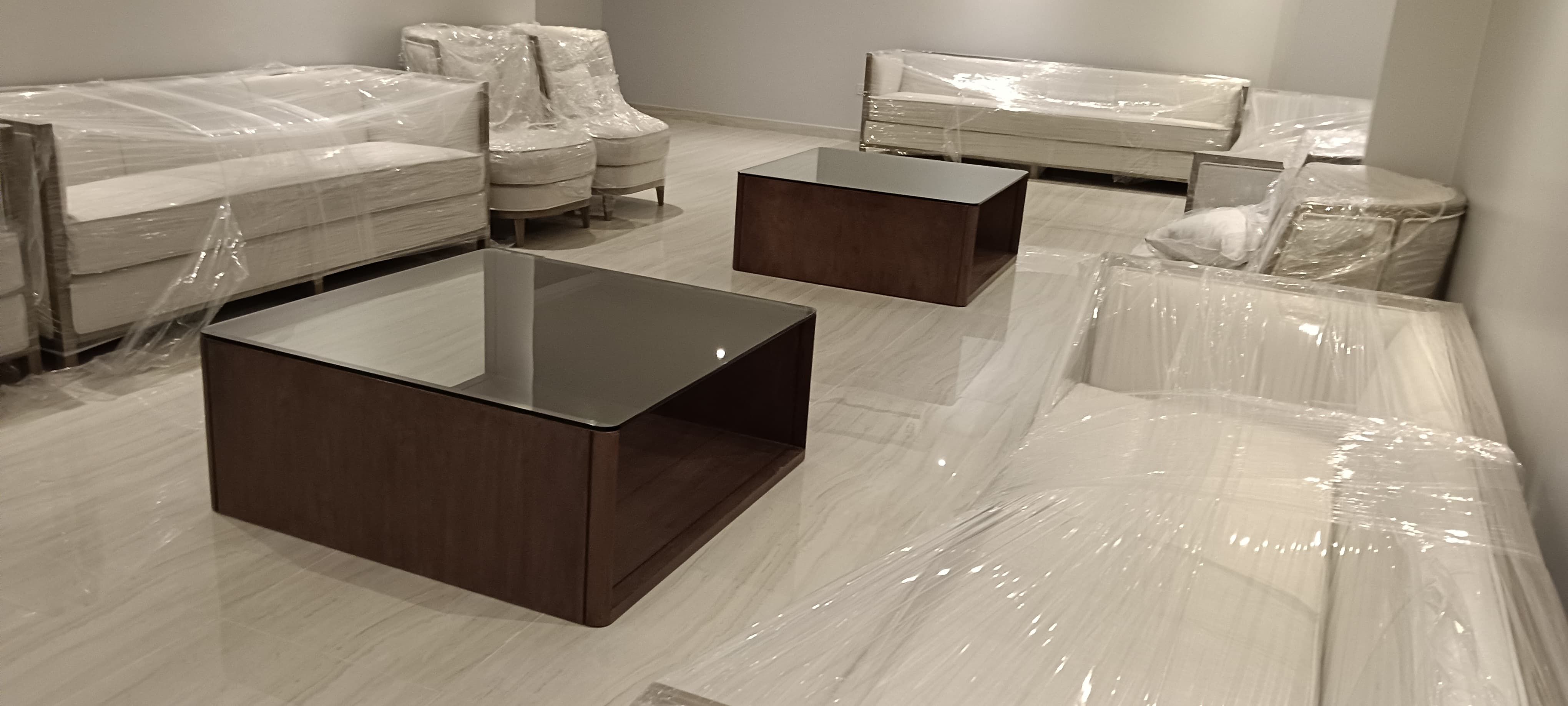 طقم من طاولتي قهوة خشبيتين بتصميم تقليدي يتميز بسطح زجاجي شفاف مدمج، مصمم ليتناسب مع المجالس الكلاسيكية أو غرف المعيشة الرسمية. - صورة 1