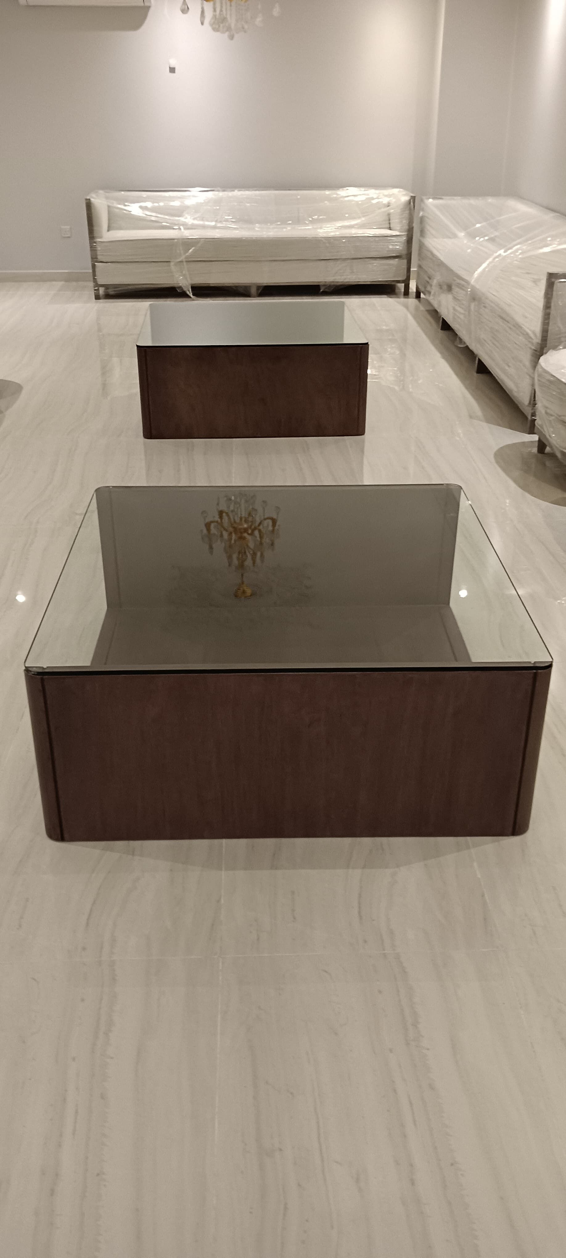 طقم من طاولتي قهوة خشبيتين بتصميم تقليدي يتميز بسطح زجاجي شفاف مدمج، مصمم ليتناسب مع المجالس الكلاسيكية أو غرف المعيشة الرسمية. - صورة 3