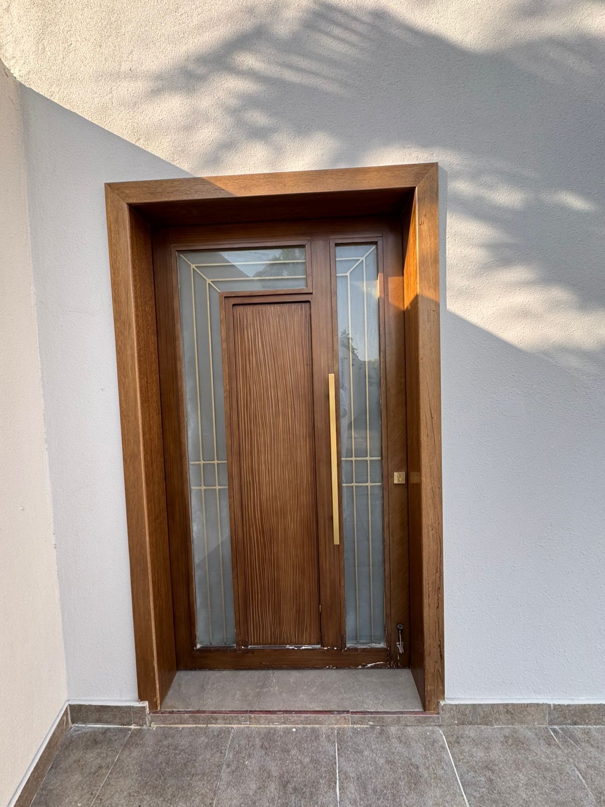 A set of matching modern exterior entryway doors crafted from natural wood panels, including a grand double-door main entrance and a coordinating single-door secondary entry. - Photo 2