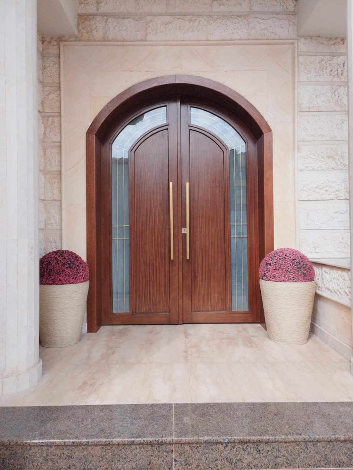 A set of matching modern exterior entryway doors crafted from natural wood panels, including a grand double-door main entrance and a coordinating single-door secondary entry. - Photo 3