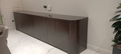 A traditional wooden dining room buffet featuring decorative multi-panel cupboard doors.