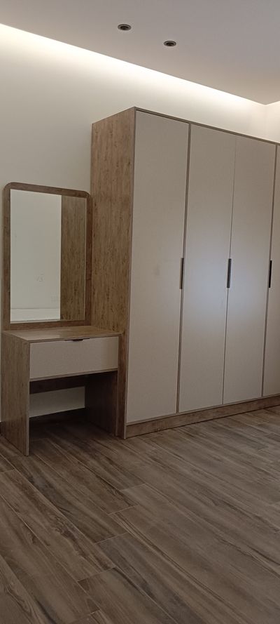 A matching bedroom furniture suite featuring a multi-door wardrobe closet, a wide storage dresser, and small nightstands, all designed with clean lines and uniform modern finishes.