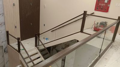 Minimalist interior staircase railings and wall-mounted handrails crafted from solid wood panels.