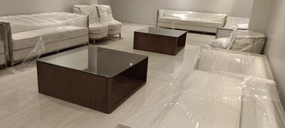 A pair of traditional wooden coffee tables featuring an integrated clear glass tabletop insert, designed to complement classic majlis or formal living room seating.