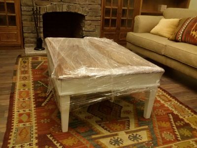 A cohesive living room table assembly featuring a low-profile central rectangular coffee table paired with matching square side tables, all finished with a rich natural wood grain veneer.